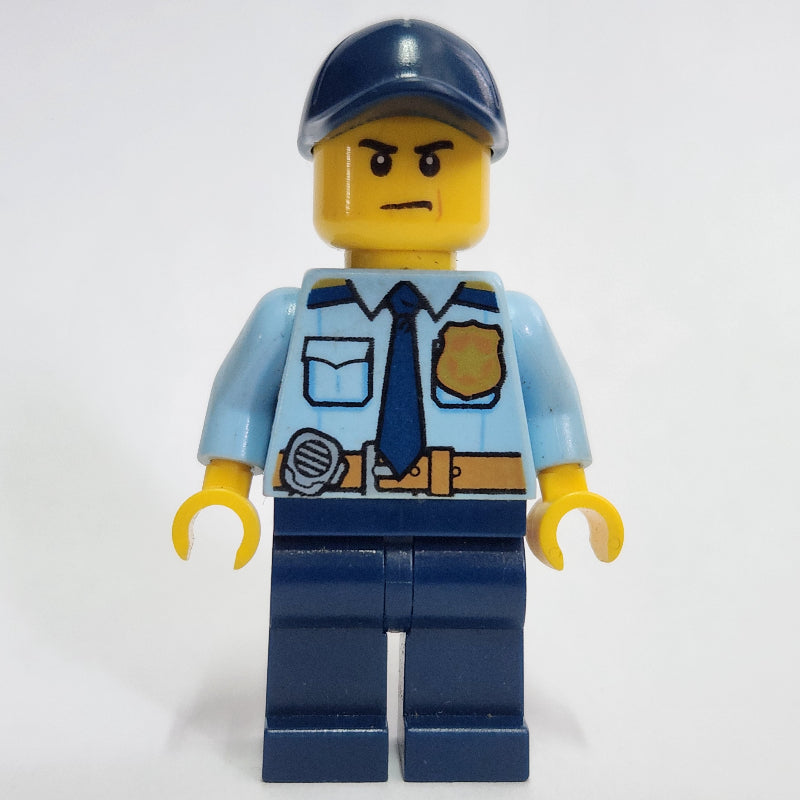 fig-001585 – Policeman, Bright Light Blue Shirt with Dark Blue Tie, Badge, and Radio on Belt, Dark Blue Cap