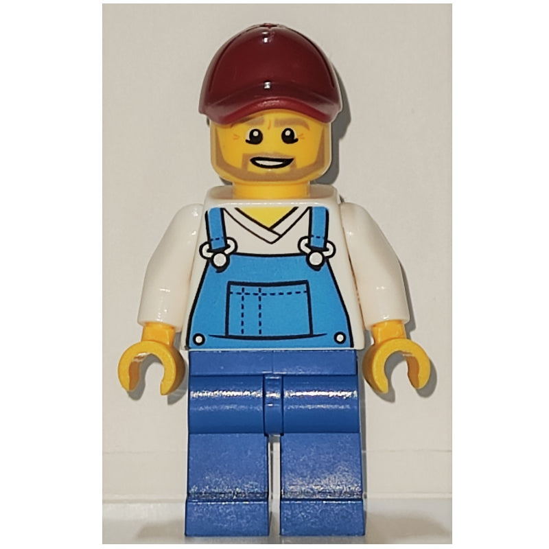 fig-001989 – Man, Blue Overalls over White V-Neck Shirt, Dark Red Cap, Beard