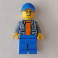 fig-007279 – Coast Guard, Open Sand Blue Jacket with Badge over Orange Sweater, Blue Cap