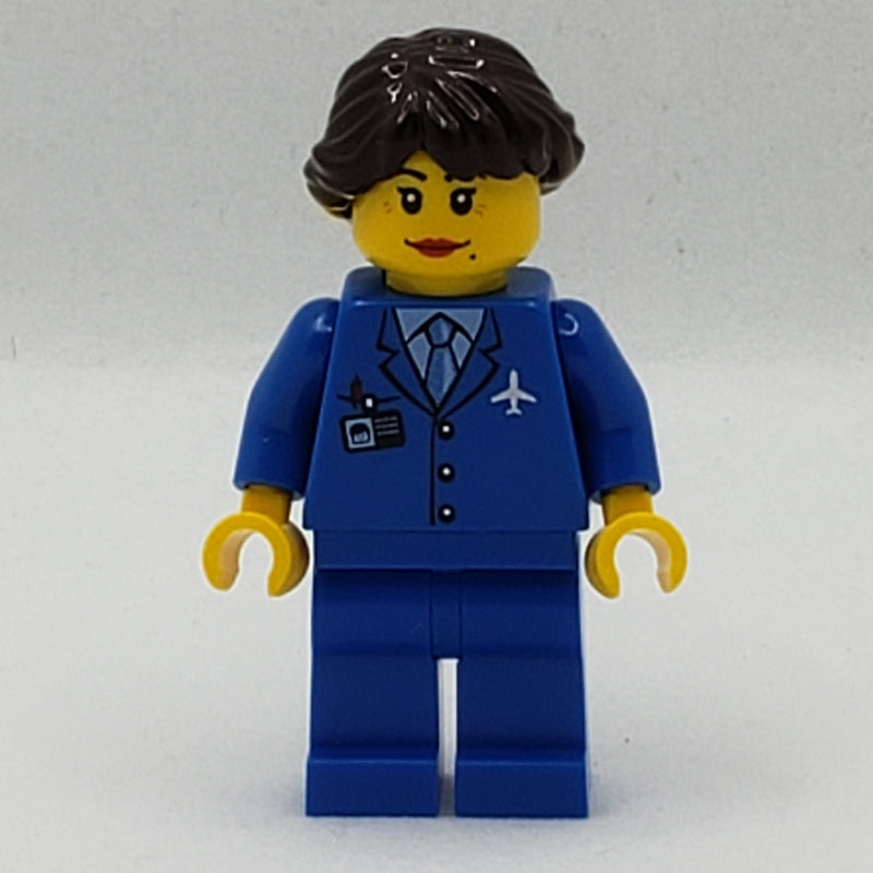 fig-007713 – Pilot, Woman, Blue Jacket with Plane Logo and Blue Tie, Blue Legs, Dark Brown Hair