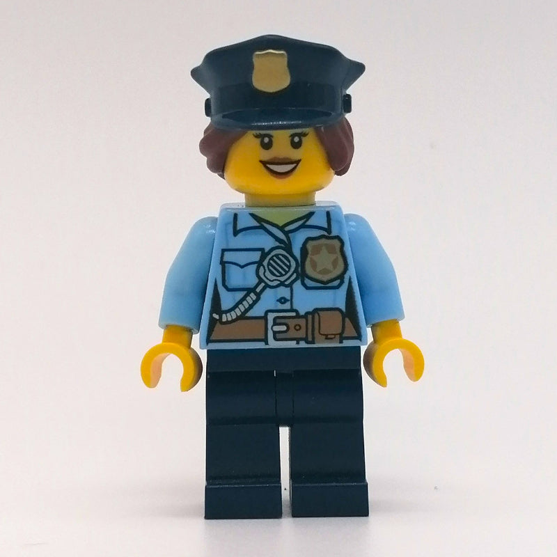 fig-007842 – Policewoman, Bright Light Blue Shirt with Radio and Badge, Dark Blue Legs, Police Hat with Badge, Open Mouth