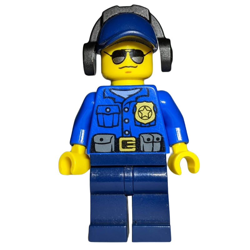 fig-007872 – Policeman, Blue Shirt with Badge and Pouches, Dark Blue Legs, Dark Blue Cap with Ear Defenders, Sunglasses