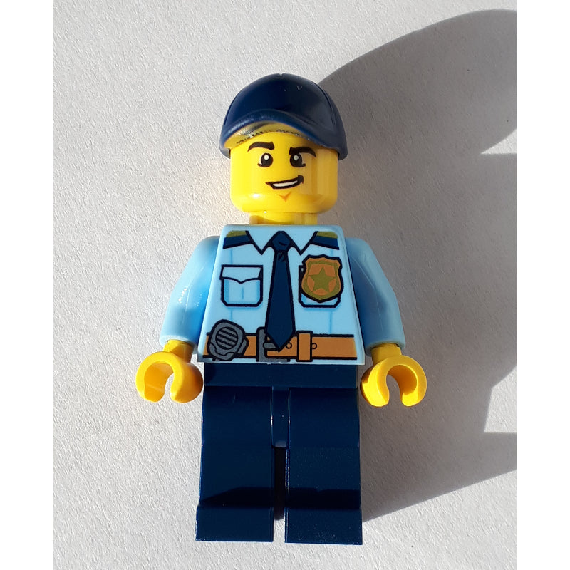 fig-007956 – Policeman, Bright Light Blue Shirt with Dark Blue Tie, Badge, and Radio on Belt, Dark Blue Cap, Open Mouth