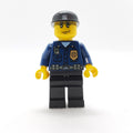 fig-008005 – Policeman, Dark Blue Shirt with Radio and Badge, Black Legs, Black Cap