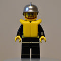 fig-008042 – Fireman, Black Fire Jacket with Reflective Stripes, Radio, and Badge, Silver Helmet, Yellow Life Vest 2610, Beard and Glasses