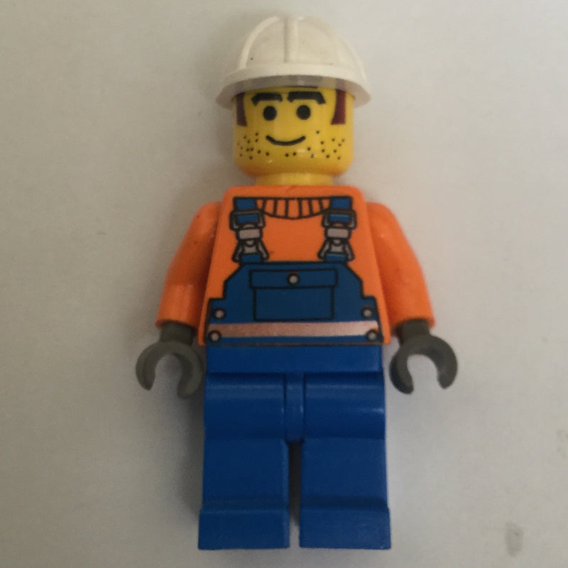 fig-008119 – Construction Worker, Blue Overalls over Orange Sweater, White Hard Hat, Printed Hair and Stubble