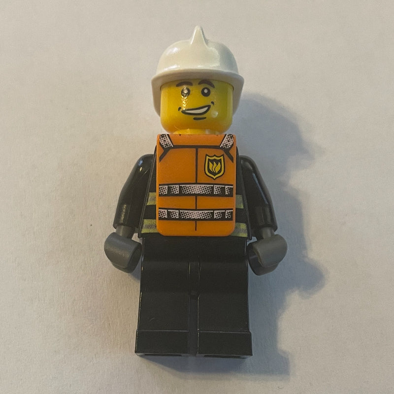fig-008152 – Fireman, Black Fire Jacket with Reflective Stripes, Radio, and Badge, White Helmet, Orange Vest