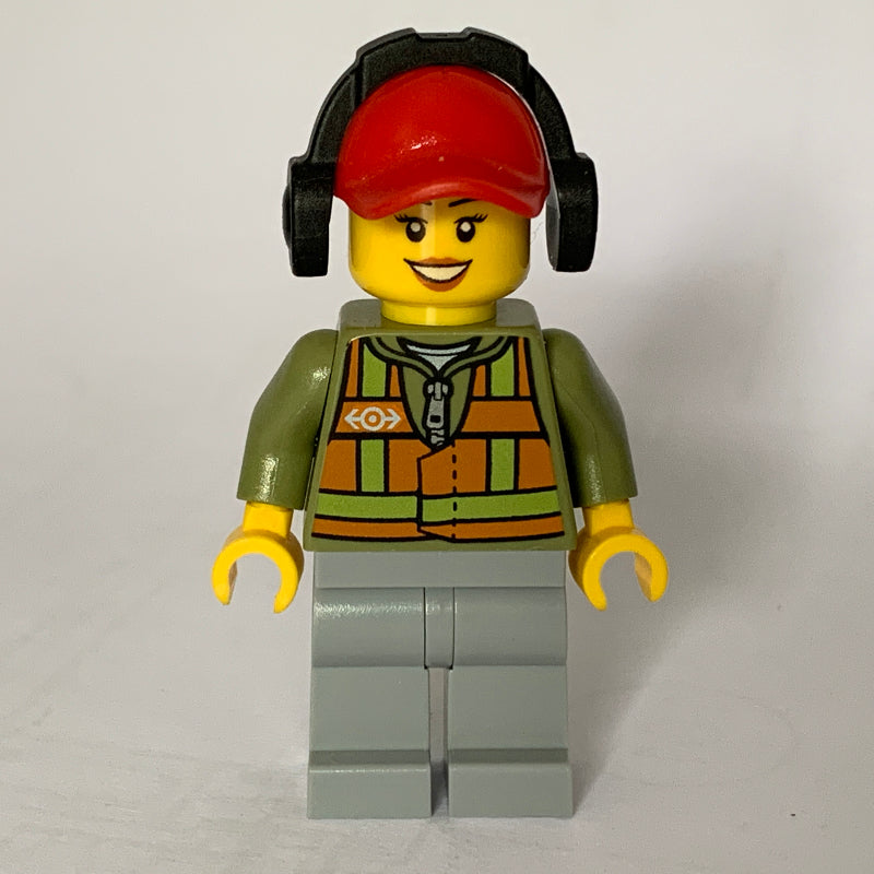 fig-009287 – Train Worker, Woman, Orange Safety Vest with Train Logo over Olive Green Hoodie, Light Bluish Gray Legs, Red Cap with Ear Defenders