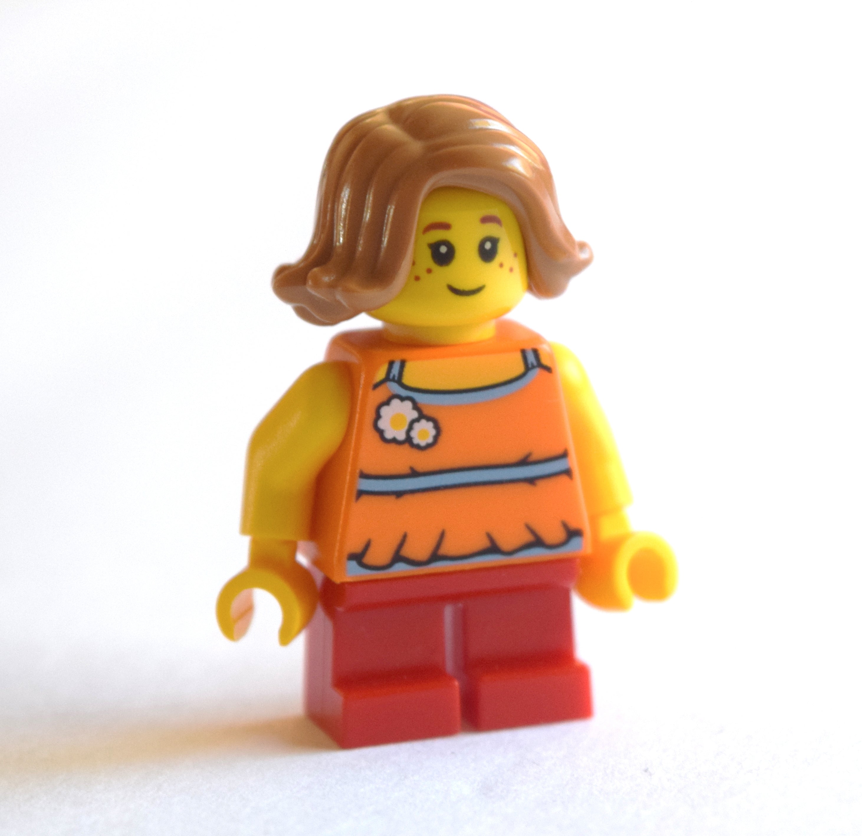 fig-009307 – Girl, Orange Top, Short Red Legs, Medium Nougat