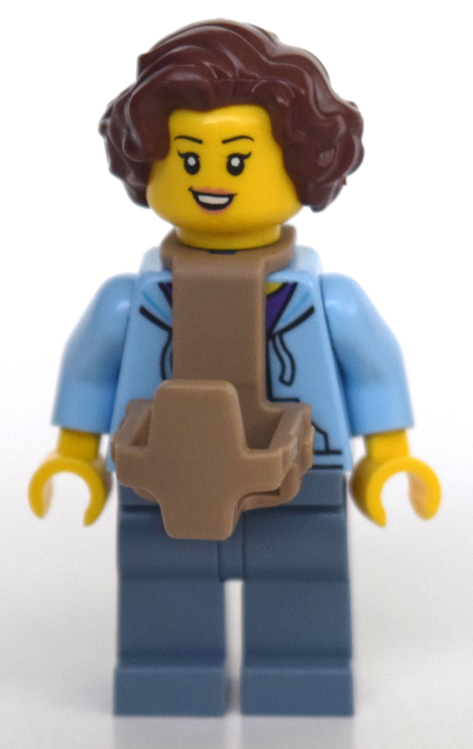fig-010793 – Woman, Open Jacket over Purple Shirt, Sand Blue Legs, Baby Carrier, Reddish Brown Hair